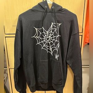 A black hoodie with a spiderweb heart in the middle from Hanes